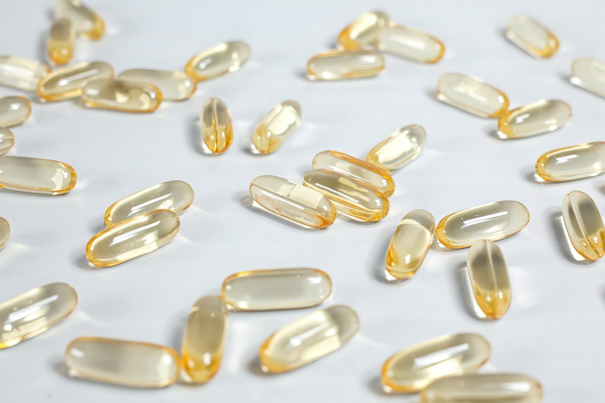 Clear soft-gel capsules scattered on a white surface
