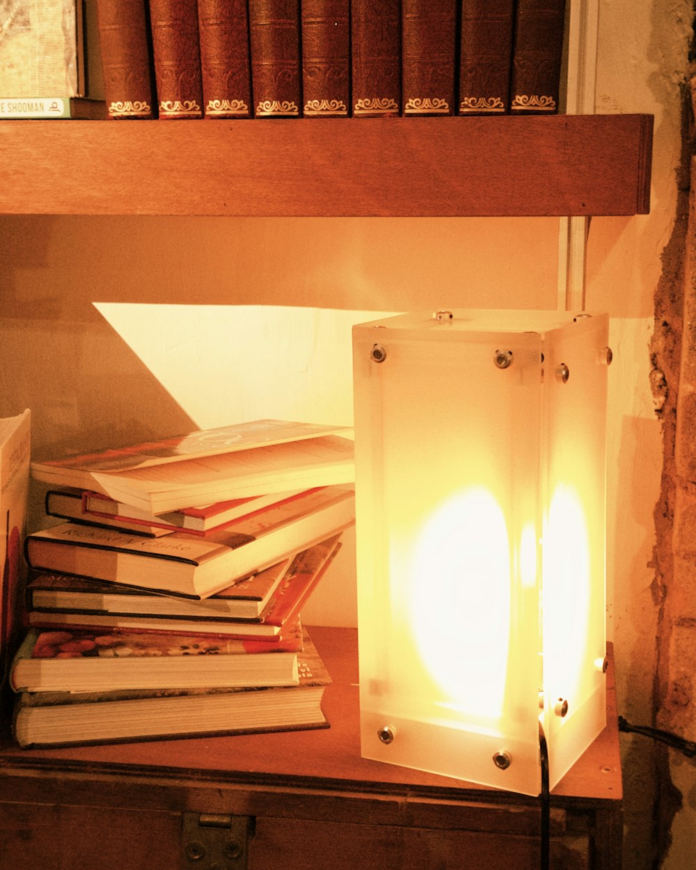 A stack of books beside a lamp