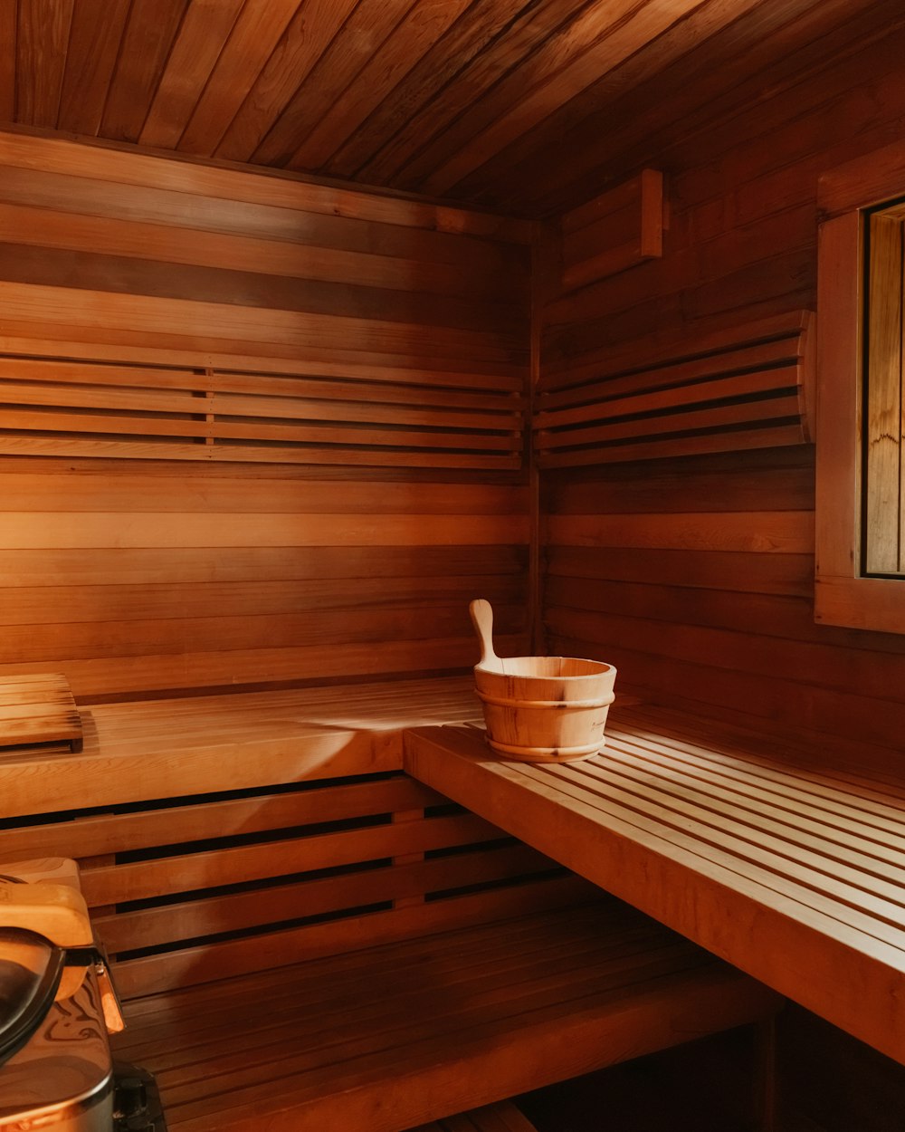An empty cedar sauna with a wooden bucket