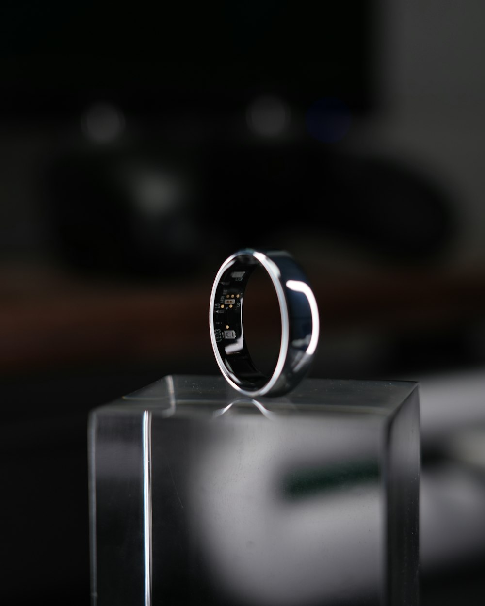 A silver smart ring on a clear block