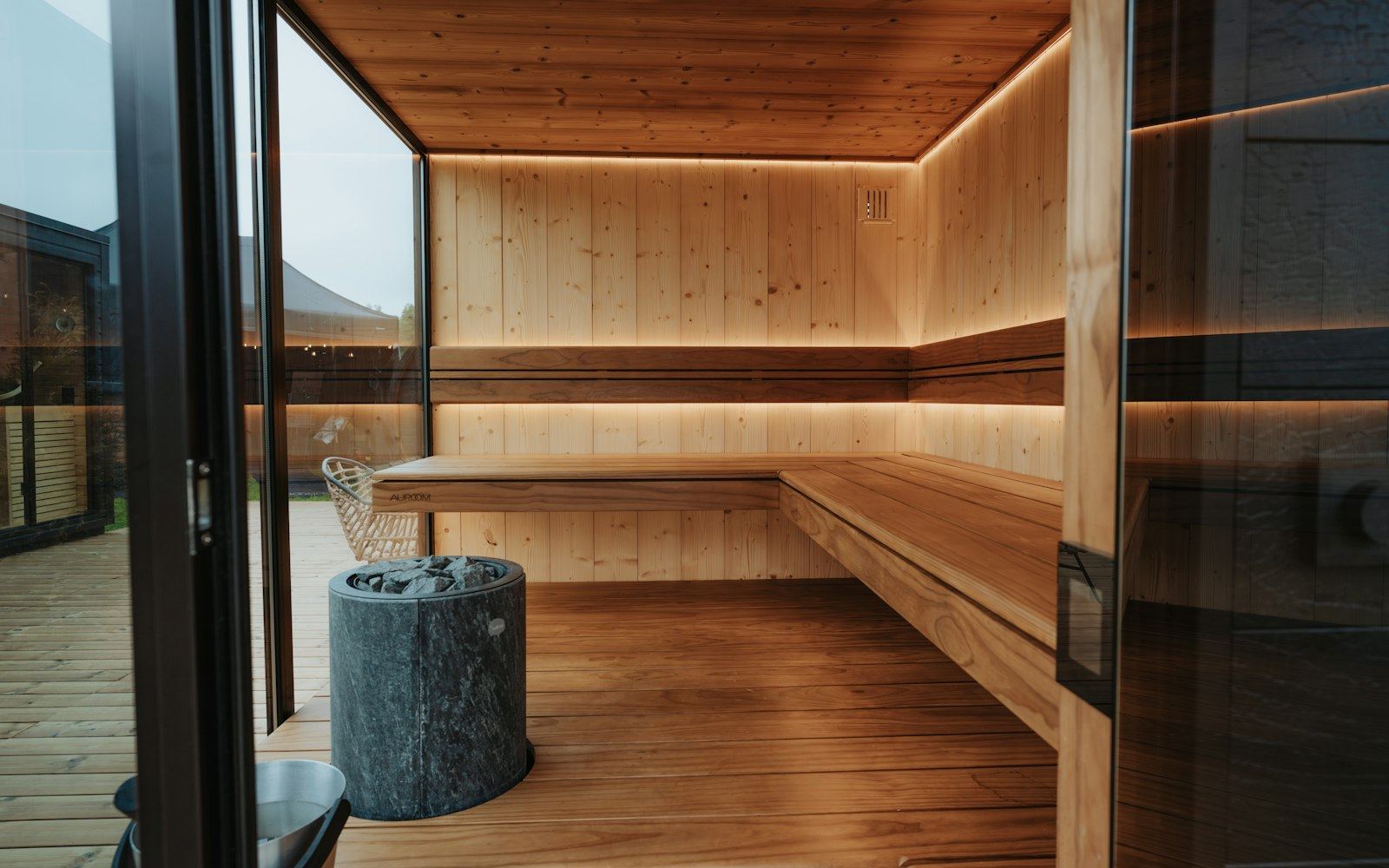 Cedar sauna benches behind a full-height glass wall